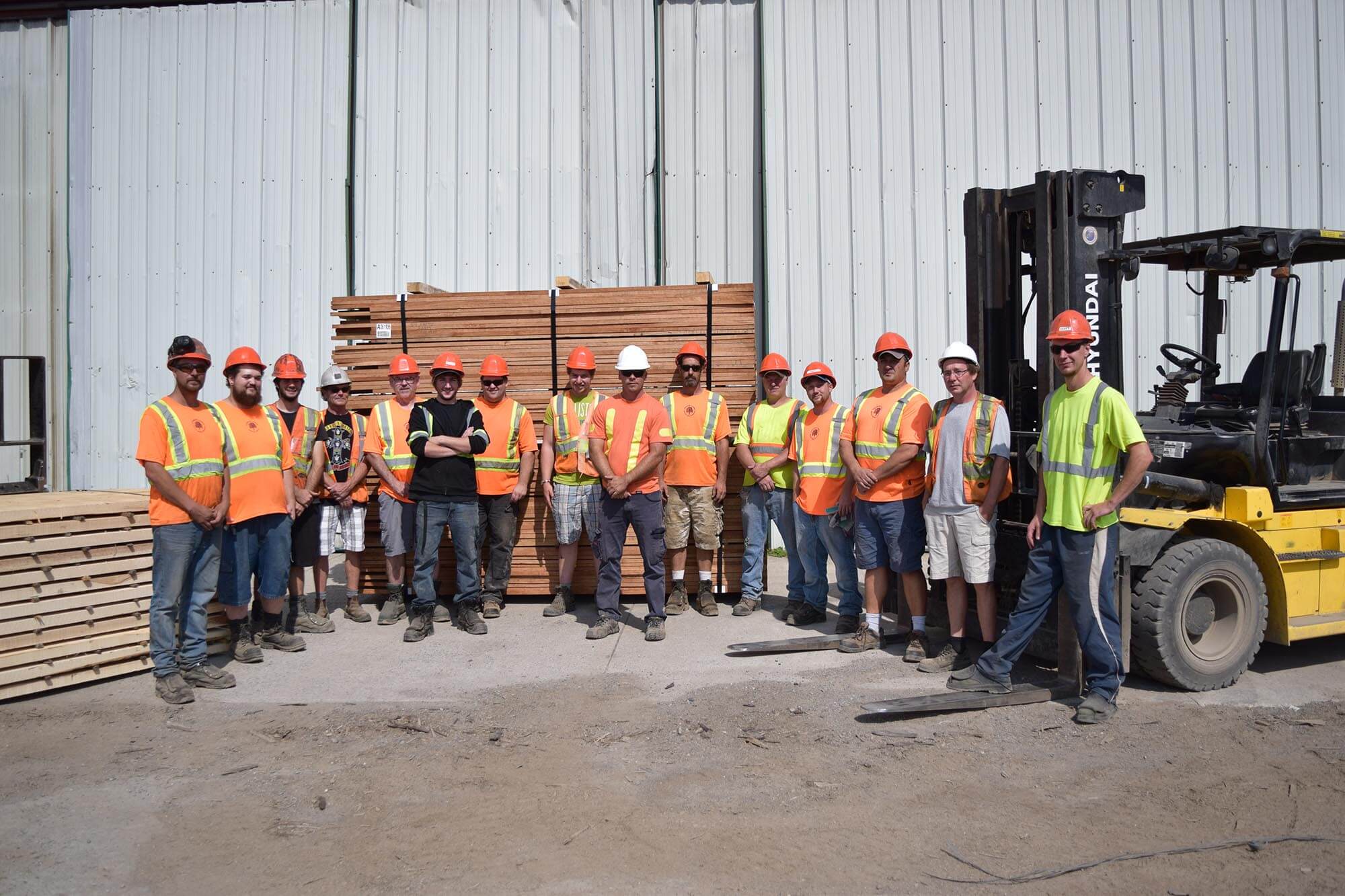 the townsend team posing outside wearhouse in front of large palettes of wood.