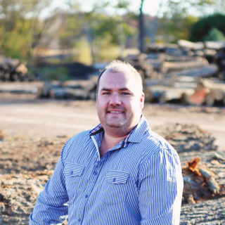 Headshot of Mike Penner in front of lumber yard.