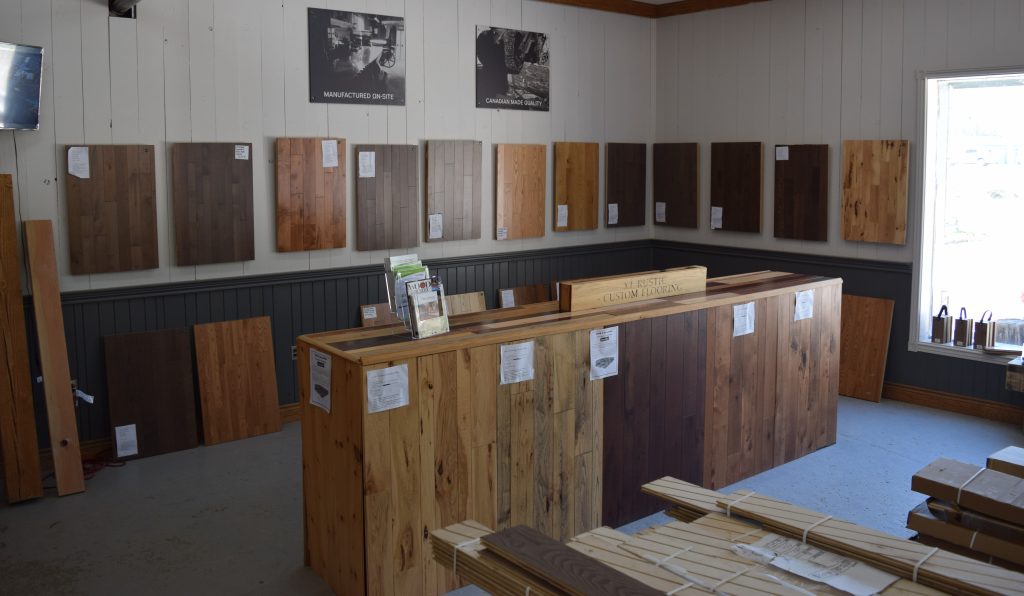 Inside a show room there are wood samples on the walls and an island in the middle with wood samples building the island.